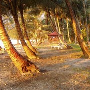 Tegen de avond komen we aan op het eiland Poncan Gadang. De avondzon strijkt langs de kokospalmen.