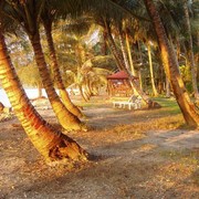 Tegen de avond komen we aan op het eiland Poncan Gadang. De avondzon strijkt langs de kokospalmen.    