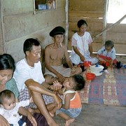 De bewoners van het eiland Pasirputih. Vier generaties in een woning op palen. Opa met visserspet in het midden, vooraan een moedertje van dertien jaar oud.    