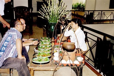 Nog een plechtig moment: thee met kwee-kwee in het hotel Tugu te Malang. Theo en Yopi laten zich informeren over de lekkernijen.    