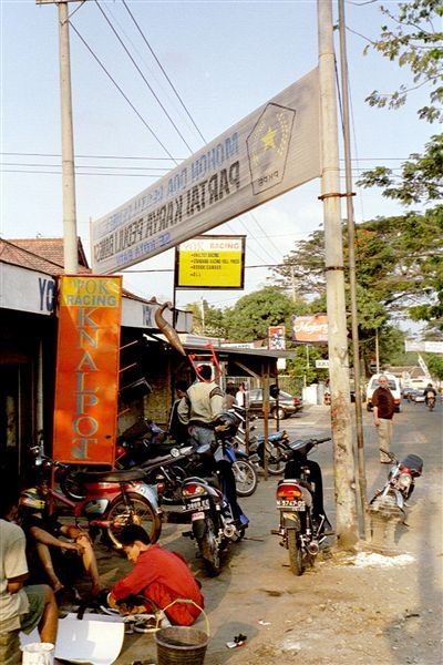 De Knalpot is kennelijk het meest kwetsbare deel van een auto. Overal langs de weg zie je bengkels (werkplaatsen) met dit opschrift. Hier staat het verticaal op het rode vlak. Eén keer zag ik zelfs "Mega-knalpot" op het uithangbord staan. Daar zit een gedachtefout in.