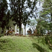 Een ondernemende Minangkabauer laat tegen betaling pony's met kinderen op hun rug rondjes rijden om de watertoren. Hij heeft het druk.    
