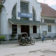 Het oude stationnetje van Pematang Siantar met een oeroude motor-becak er voor.
