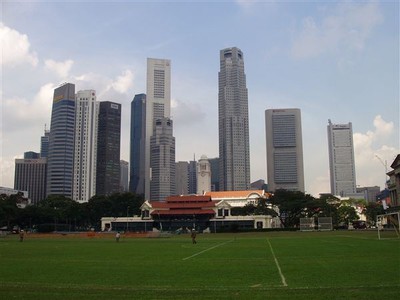 De Padang (cricketveld, nog steeds in gebruik) in het hart van koloniaal Singapore. Op de achtergrond het clubgebouw en de nieuwe skyline    