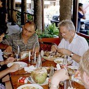 Vol overgave zitten Eric, chauffeur Yul, het achterhoofd van Theo en ik aan de lunch in Surabaya. Ik had de Gurami Bakar, geroosterde baars met ketjap-saus. Overheerlijk! Er staat ook een kelapa muda (jonge kokosnoot) op tafel om de dorst te lessen.