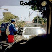 Op een druk kruispunt in de stad probeert een gitarist wat te verdienen.    