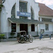 Het oude stationnetje van Pematang Siantar met een oeroude motor-becak er voor.    