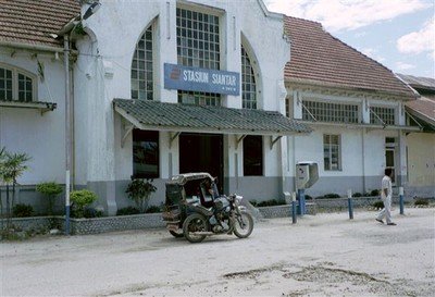 Het oude stationnetje van Pematang Siantar met een oeroude motor-becak er voor.    
