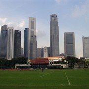 De Padang (cricketveld, nog steeds in gebruik) in het hart van koloniaal Singapore. Op de achtergrond het clubgebouw en de nieuwe skyline