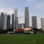 De Padang (cricketveld, nog steeds in gebruik) in het hart van koloniaal Singapore. Op de achtergrond het clubgebouw en de nieuwe skyline    