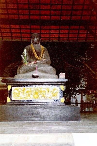 Tegenover het paleis staat de Jogodolok, het aloude beeld van een Javaanse prins in buddha-zit. Vroeger stond het hier onder een waringin, nu is er een altaargebouwtje voor opgericht en staat de prins droog. Zijn stenen ogen kijken vredig op ons neer.