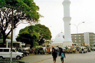 Op de overvolle, drukke alun-alun van Bandung staat een forse witte moskee, veel groter dan de maten van het plein eigenlijk toelaten.    