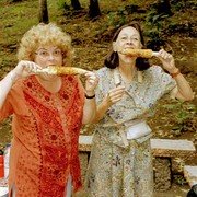 Aan de ingang van de waterval is koffie te koop en roosteren ze mais (jagung). Martine (links) en Maja genieten.