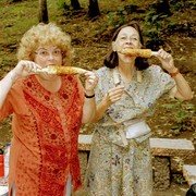 Aan de ingang van de waterval is koffie te koop en roosteren ze mais (jagung). Martine (links) en Maja genieten.    