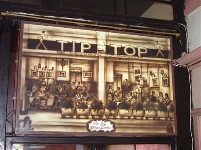 Binnen hangt een reclame-tekening in sepia-tinten waarop te zien is hoe hier ooit grote koloniale gezelschappen bezig waren vrolijk te zijn