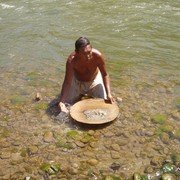 De mengeling van zand en water in de schaal begint te draaien. De lichte zandkorrels lopen over de rand van de schaal weer de rivier in, terwijl het zwaardere goudpoeder bezinkt. Als hij dit twee dagen doet heeft hij 1 gram goud, daar krijgt hij 2 euro voor.