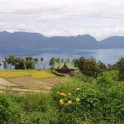 Minangkabau's droomhuis op een plateau boven het meer. De puntdaken symboliseren de hoorns van de karbouw