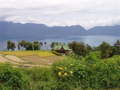 Minangkabau's droomhuis op een plateau boven het meer. De puntdaken symboliseren de hoorns van de karbouw